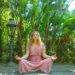 woman in pink dress sitting on wooden pathway